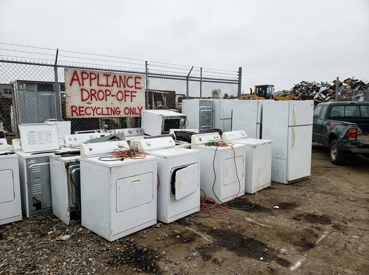 Stack of old appliances at a scrap metal recycling drop-off center for appliance disposal
